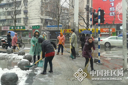 社区工作人员冒着严寒扫除道路上的积雪.jpg