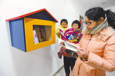 社区居民24日在荣域社区的“鸟巢图书馆”前翻阅图书450.jpg