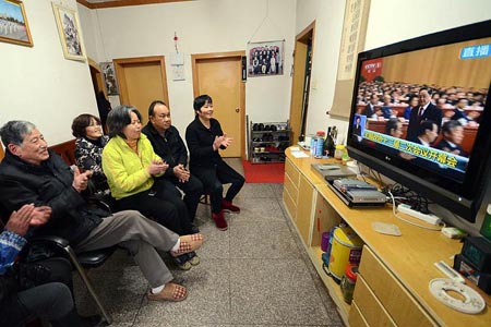 南昌居民在家中通过电视观看全国政协十二届二次会议开幕会。.jpg