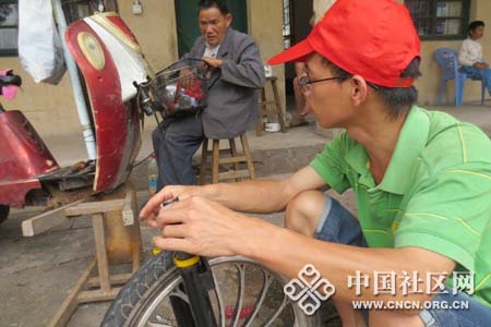 志愿者为老人修理自行车.jpg